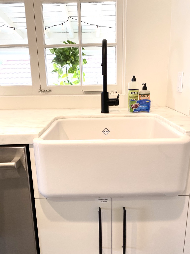 Farmhouse sink with matte black faucet in remodeled kitchen