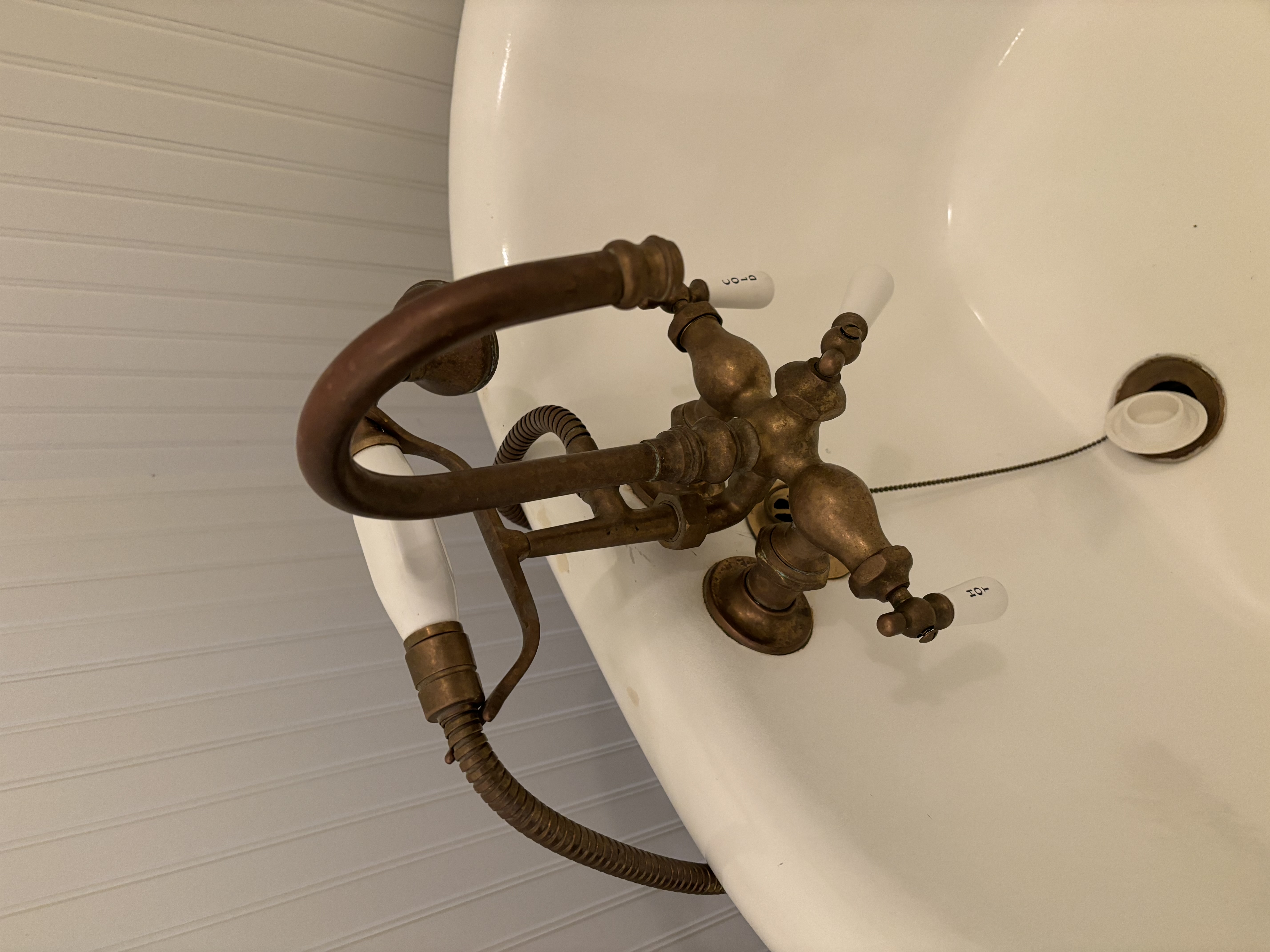 Restored antique clawfoot tub with vintage brass faucet set