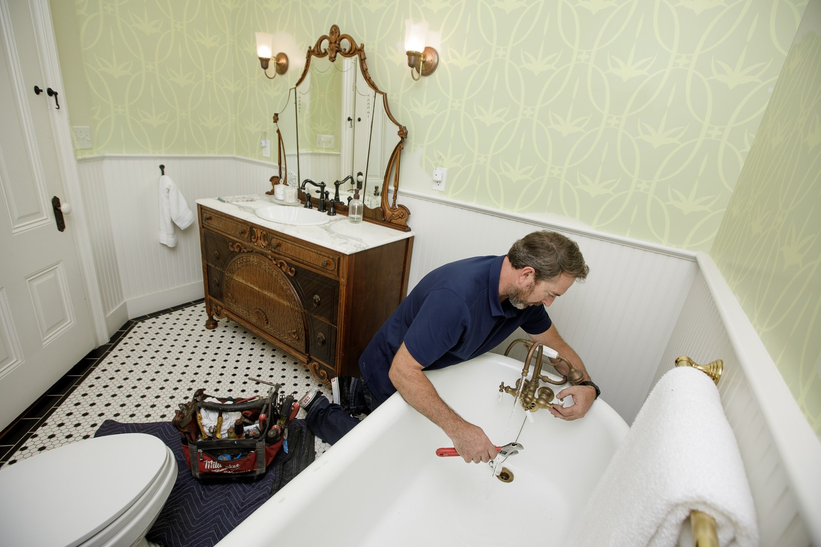 Restored antique clawfoot tub and vintage brass faucet set in a downtown Victorian bathroom
