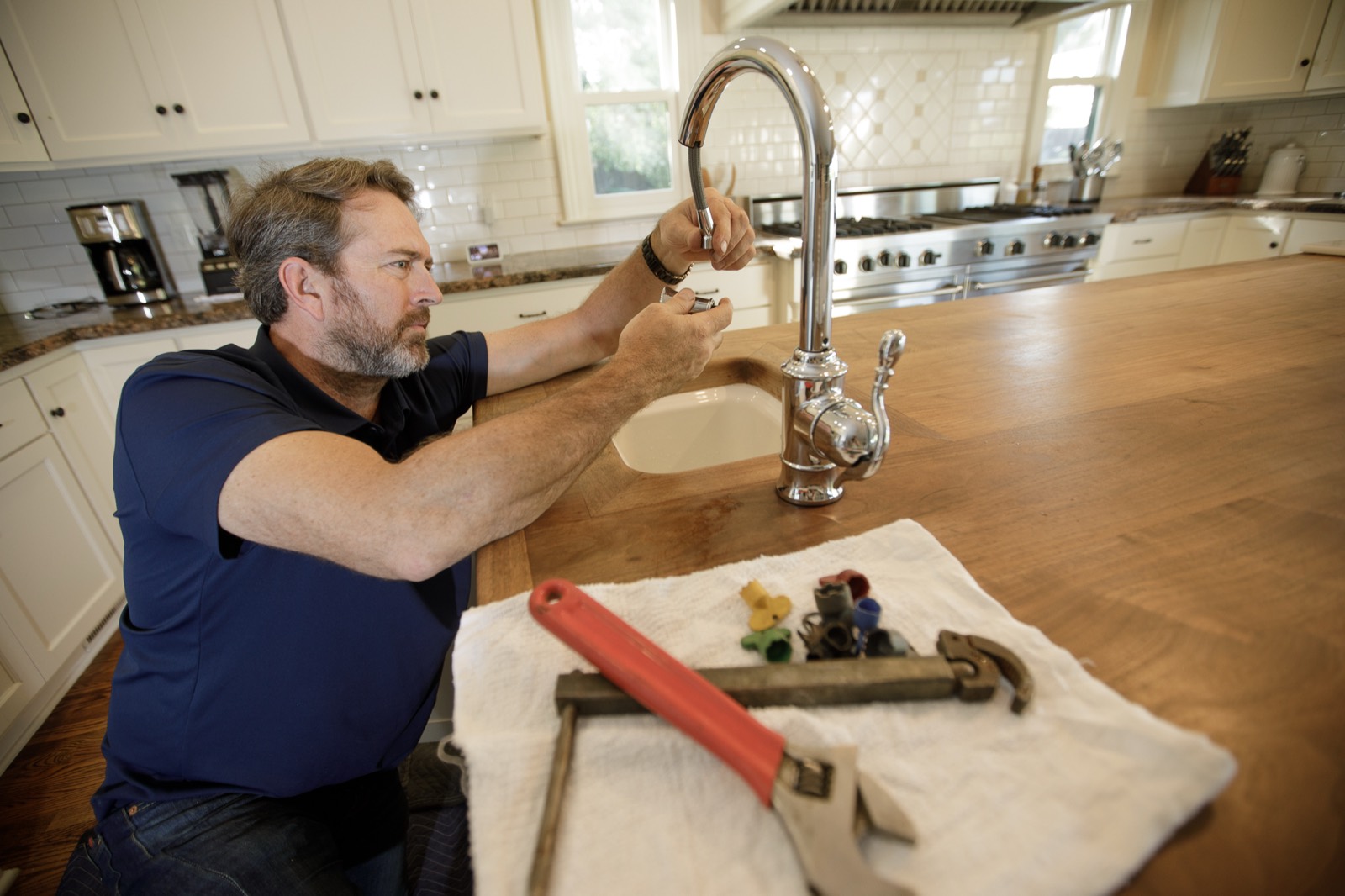 Joe installing a new kitchen faucet on a walnut countertop