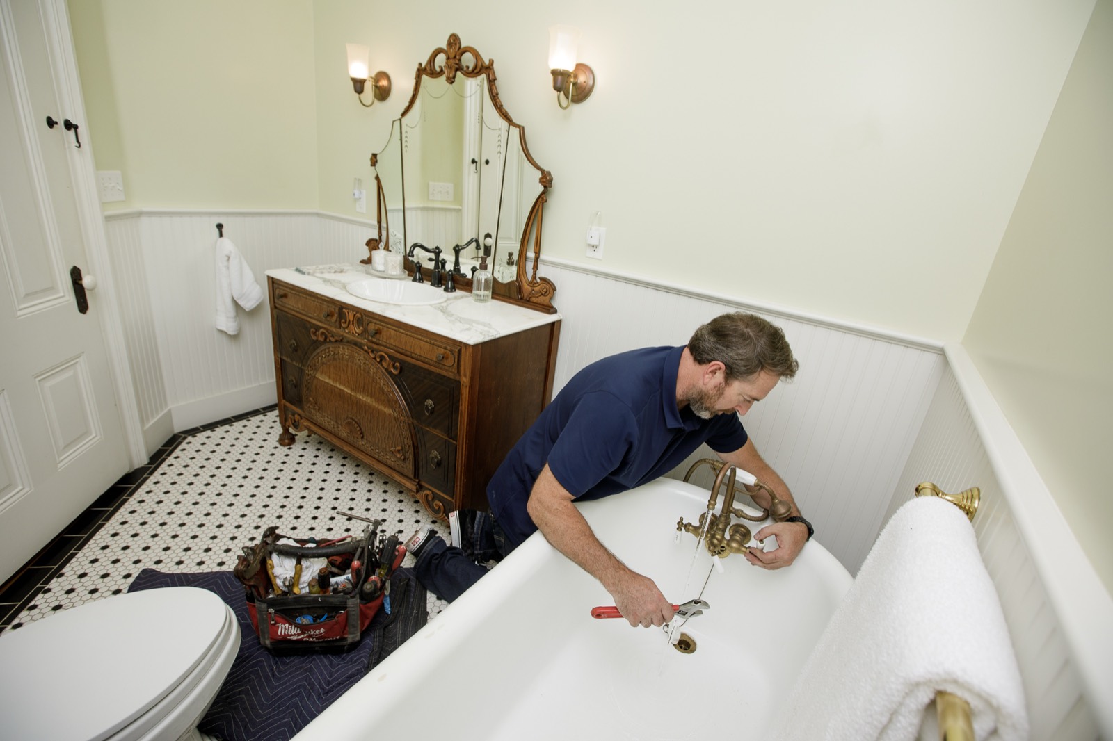 Joe fitting a vintage brass tub filler during a period bathroom remodel
